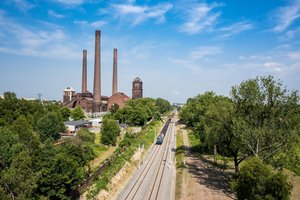 Pociąg towarowy jedzie po nowych torach między Bytomiem a Bytomiem Bobrkiem. Widać elektrociepłownię Szombierki, fot. Szymon Grochowski