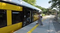 Pociąg i podróżna na przystanku Lubachów_08.07.2023_autor Jakub Żarkowski_źródło PKP Polskie Linie Kolejowe S.A.