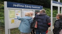 Podróżni sprawdzający rozkład jazdy na przystanku Jedlina-Zdrój Centrum_01.07.2023_autor Jakub Żarkowski_źródło - PKP Polskie Linie Kolejowe S.A.